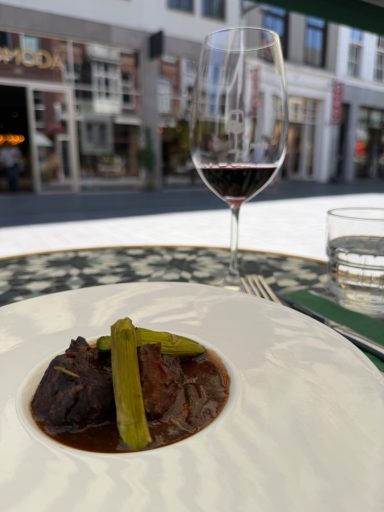 Social media management | DE WIJNCLUB Breda Gastronomisch gerecht met een glas rode wijn op het terras van restaurant DE WIJNCLUB in Breda, gefotografeerd voor social media content.
